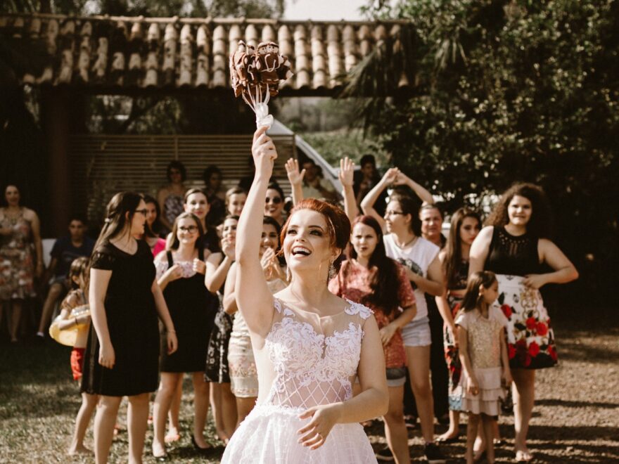 bride throwing flower bouquet on women during daytime